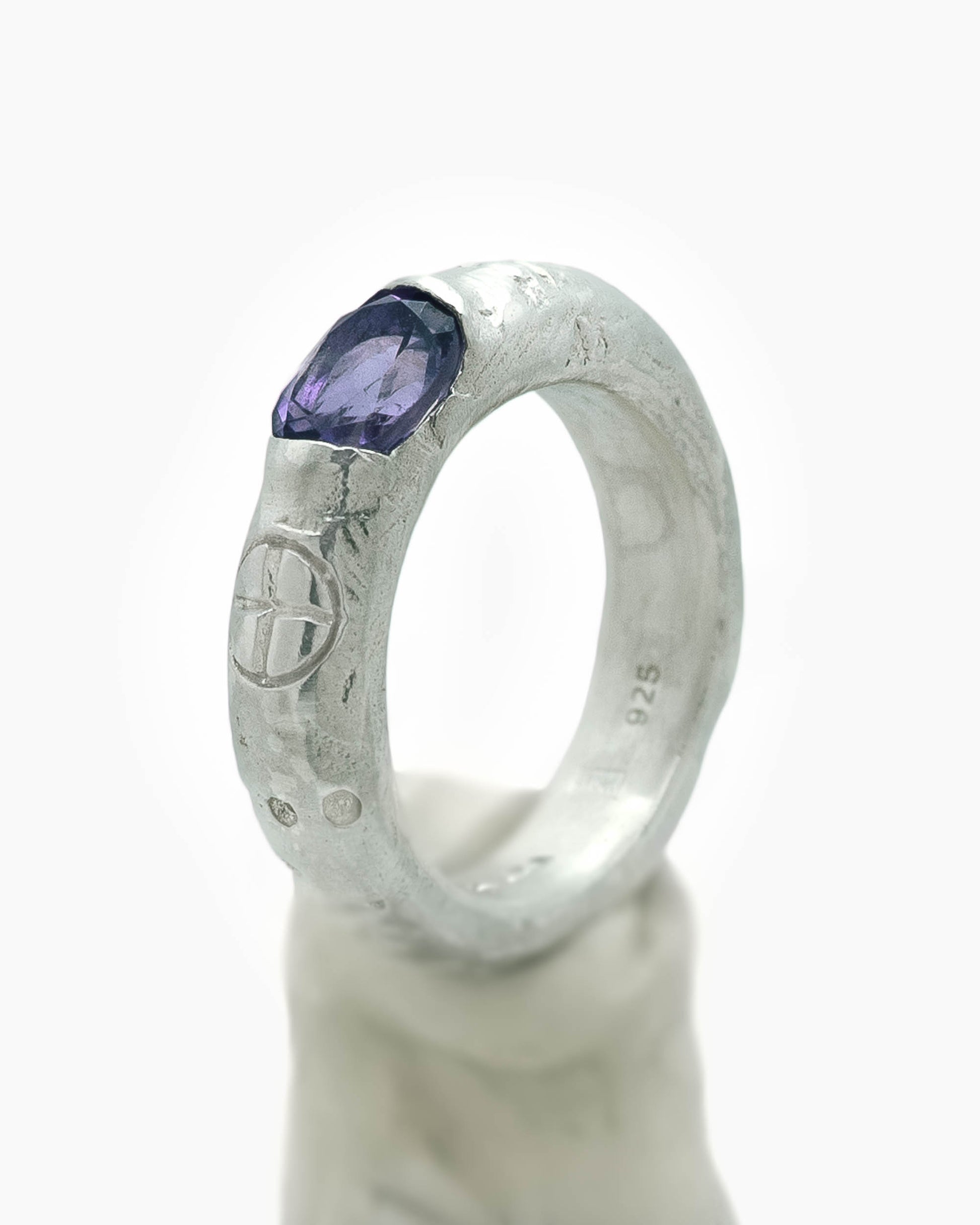Silver ring with an african amethyst stone in the center and engravings